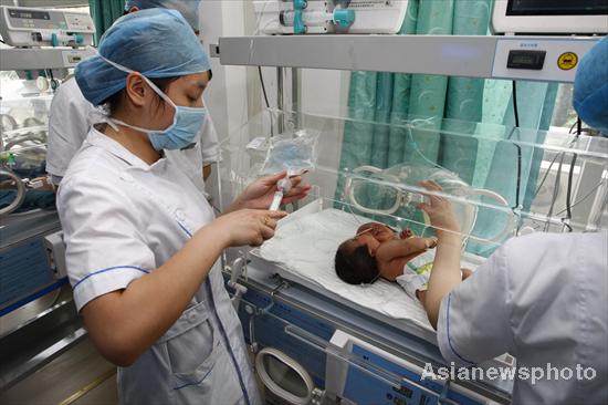 Conjoined twins that resemble a baby girl with two heads born on May 5 receive treatment at a hospital in Suining, Sichuan province, on Monday. The twins, 51cm long and weighing 4.05 kg, are still in a dangerous condition. The case is the first of its kind in China. [Asianewsphoto]