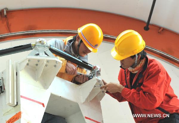 Engineers of the National Astronomical Observatory of China debug facilities at the astronomical observation station in Yangbajain, southwest China's Tibet Autonomous Region, May 7, 2011. Installed at an altitude of 4,300 meters, the KOSMA millimeter telescope, a project cooperated by China and Germany, enters the phase of debug recently. It is one of the most advanced astronomical observation facilities to observe the outer space. [Chen Haining/Xinhua]