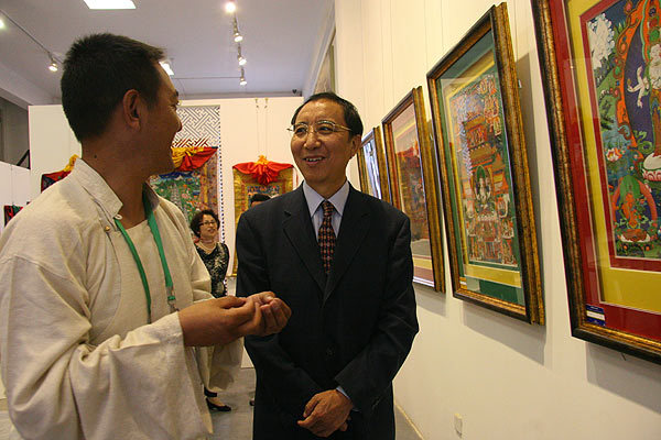 Thangka artist Norbu Sida (L) discusses painting techniques with Sita (R), vice minister of the United Front Work Department of the CPC Central Committee. 