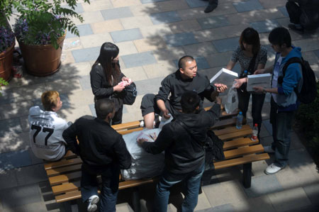 Scalpers wait for iPad 2 buyers outside the Apple store in Sanlitun, Beijing on Saturday. 