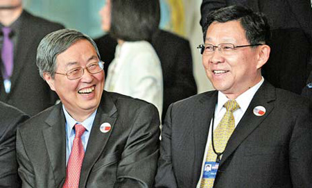 Minister of Commerce Chen Deming (right) and Bank of China Governor Zhou Xiaochuan smile while taking their places for the China-US Strategic and Economic Dialogue group photo at the State Department in Washington on Monday. [China Daily via agencies]