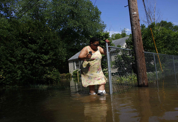 Jennifer Chambers wades out of her yard as floodwaters slowly rise in Memphis, Tennessee May 9, 2011. [China Daily] 