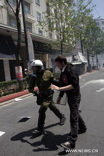 A Greek protester clashes with anti-riot police during a march against austerity measures in central Athens, capital of Greece, May 11, 2011. The two umbrella labor unions of private and public sector employees GSEE and ADEDY staged the second nationwide 24-hour general strike this year over austerity policies implemented to tackle an acute debt crisis. [Xinhua]