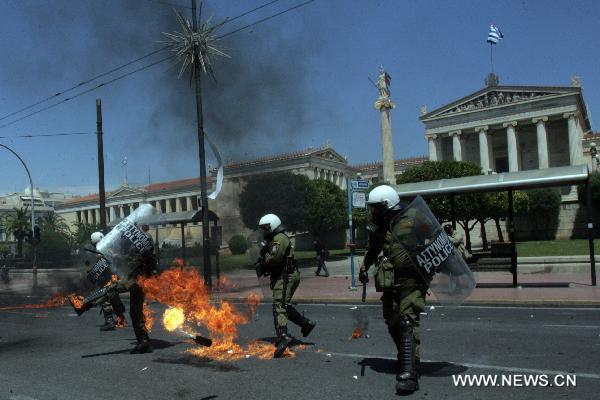 Greek demonstrators clash with anti-riot police during a march against austerity measures in central Athens, capital of Greece, May 11, 2011. The two umbrella labor unions of private and public sector employees GSEE and ADEDY staged the second nationwide 24-hour general strike this year over austerity policies implemented to tackle an acute debt crisis. [Xinhua]