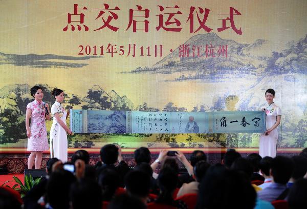 Staff of the Zhejiang Provincial Museum introduce 'The Leftover Mountain Painting', the smaller half of a 660-year-old landscape painting 'Dwelling in the Fuchun Mountains' by famed Chinese painter Huang Gongwang, with its replica during a delivery ceremony held in Hangzhou, east China's Zhejiang Province, May 11, 2011.