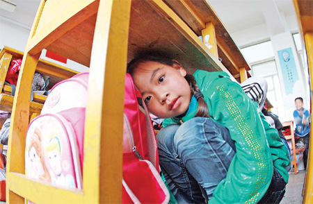 Children undergo an earthquake drill on Wednesday at their primary school in Lianyungang, Jiangsu province. Schools, hospitals and government institutions have become more diligent about preparing for emergencies since the earthquake in Sichuan province three years ago. 
