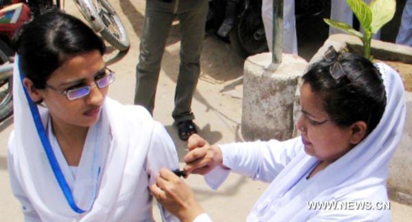 A woman member of Young Nurses Association (YNA) ties black band to her colleague as they are protesting in favor of their demands on International Nursing Day in southwest Pakistan's Quetta, on May 12, 2011. [Xinhua/Hassan]