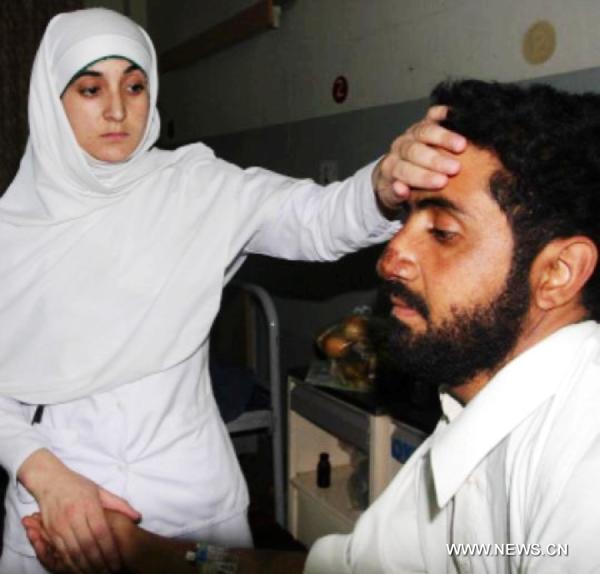 A Pakistani nurse checks a man at a hospital on the occasion of International Nursing Day in southwest Pakistan's Quetta, on May 12, 2011. [Xinhua/Hassan]