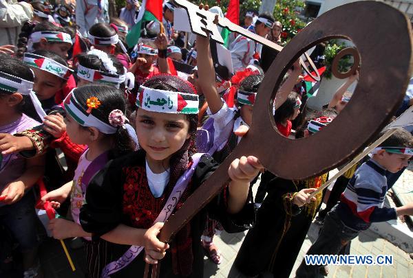 A Palestinian girl holds a key symbolizing returning home during a rally in Gaza City, May 12, 2011. [Xinhua/Yasser Qudih]