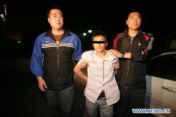 Shi Baikui(C) is escorted by police in Beijing, capital of China, May 11, 2011.