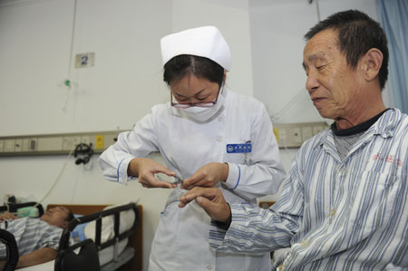 At Xuan Wu Hospital in Beijing, a nurse clips a patient's fingernails. On October 19, the Beijing Health Bureau proposed the decade-old 9 yuan daily nursing charge be raised ten times to 90 yuan a day. 
