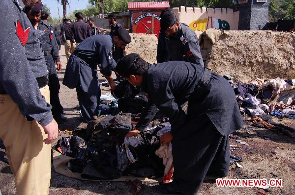 Pakistani policemen inspect the blast site in northwest Pakistan&apos;s Charsadda on May 13, 2011. [Xinhua/Saeed Ahmad]