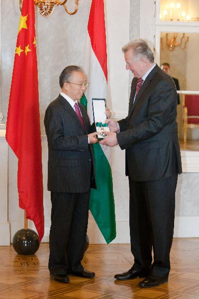 Hungarian President Pal Schmitt (R) presents the Middle Cross Honour of the Hungarian Republic to visiting State Councilor of China Dai Bingguo in Budapest, Hungary, on May 13, 2011. The second round of China-European Union strategic dialogue was held here on Thursday with the two sides having exchanged views on a wide range of issues. [Xinhua]