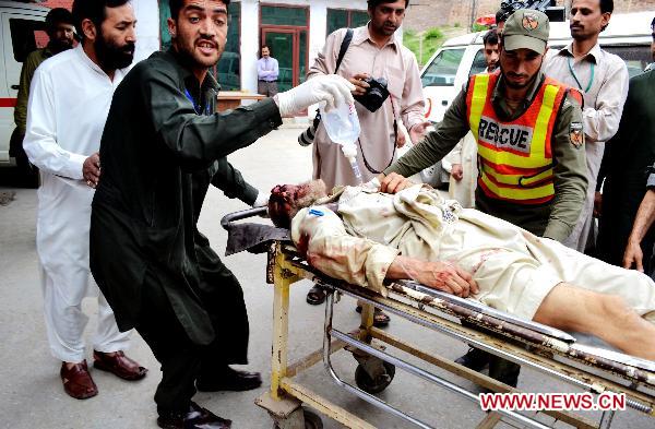 People transfer an injured man to a hospital in northwest Pakistan's Peshawar, May 13, 2011. At least 80 people were killed and dozens injured in a twin suicide blast that took place early Friday morning at a military training center in Charsadda, a city some 30 kilometers northeast of Peshawar in northwest Pakistan. [Xinhua/Umar Qayyum] 