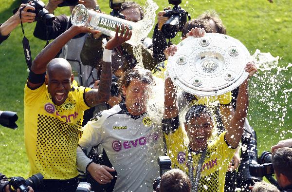 Dortmund players celebrate with beer after beating Frankfurt into second division on May 14 in Berlin. Dortmund received their trophy after beating Frankfurt with a 3-1 victory at the final round of Bundesliga on Saturday.  (Xinhua/Reuters Photo)