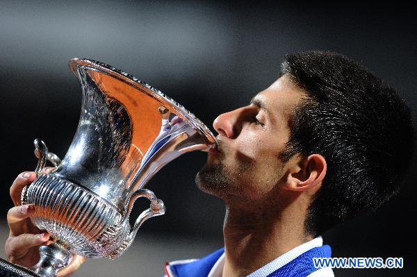 Novak Djokovic of Serbia kisses the trophy at the awarding ceremony after winning the men's singles final against Rafael Nadal of Spain at the Rome Masters tennis tournament in Rome, capital of Italy, May 15, 2011. Djokovic won 2-0 to claim the champion. (Xinhua/Wang Qingqin)