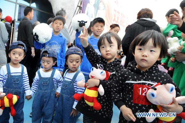 Twins prepare to take part in a contest in Qingdao, east China's Shandong Province, May 14, 2011. Some 100 pairs of twins participated in the contest at Qingdao Polar Ocean World on Saturday. [Xinhua/Li Ziheng]