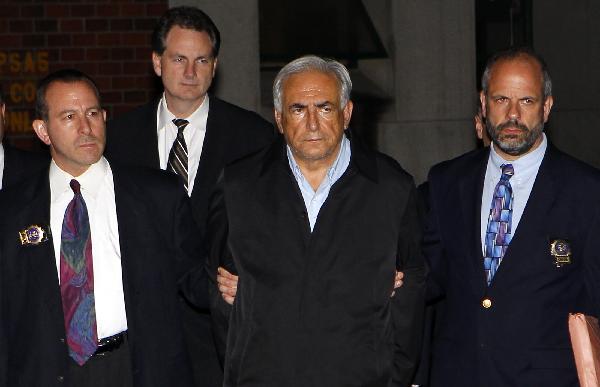 International Monetary Fund (IMF) Managing Director Dominique Strauss-Kahn (front 2nd R) leaves New York Police Department Special Victims Unit headquarters in Harlem May 15, 2011.