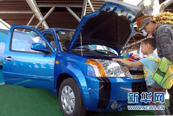 People visit the electric cars at the 17th Beijing Science and Technology Week on May 15, 2011. Beijingers who buy electric cars could avoid having to take part in the license plate lottery. 