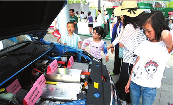 People visit the electric cars at the 17th Beijing Science and Technology Week on May 15, 2011. Beijingers who buy electric cars could avoid having to take part in the license plate lottery. 