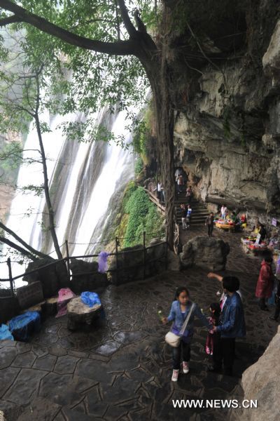 Tourists visit a waterfall cave beside Huangguoshu Waterfall in southwest China&apos;s Guizhou Province, May 15, 2011. Due to the continuous heavy rainfall, the Huangguoshu Waterfall has entered into the high flow period ahead of time, closely followed by its tourist season. 