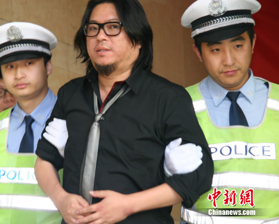 Chinese pop singer Gao Xiaosong is questioned by police after he was caught drunk driving Monday night in Beijing, May 10, 2011.