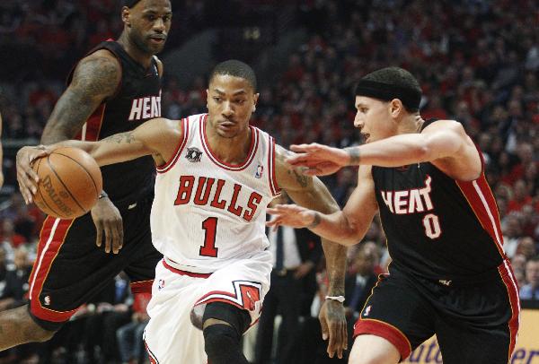 Chicago Bulls' Derrick Rose (C) is guarded by Miami Heat's Mike Bibby and LeBron James (L) during Game 1 of their NBA Eastern Conference Finals playoff basketball game in Chicago May 15, 2011. (Xinhua/Reuters Photo) 