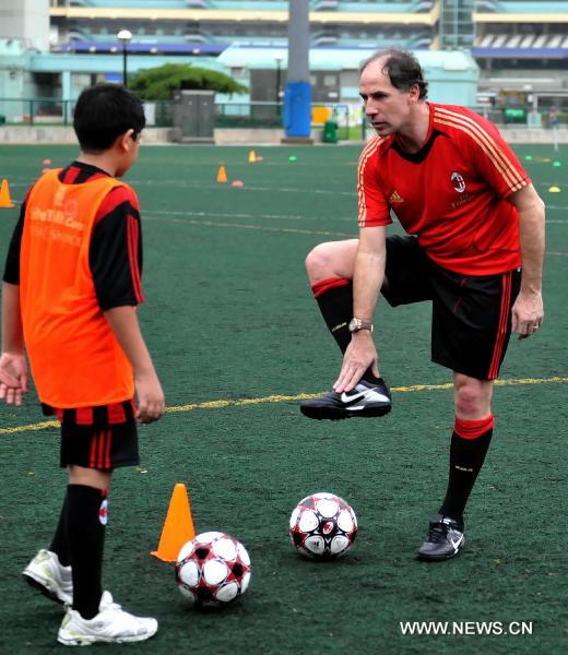 Italian football legend Franco Baresi (R) shows football skills after the media conference in Hong Kong, south China, May 16, 2011 to announce the launch of AC Milan Soccer Schools in Hong Kong. (Xinhua/Lo Ping Fai)