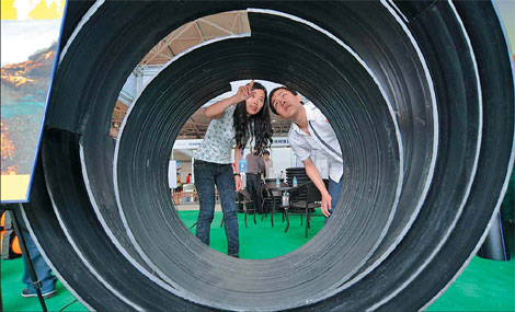 A worker displays energy-saving building materials to a visitor at an exhibition in Guiyang, capital city of Guizhou province. The Asian Development Bank has allocated $124 million to help boost the energy efficiency in buildings in China. [China Daily] 