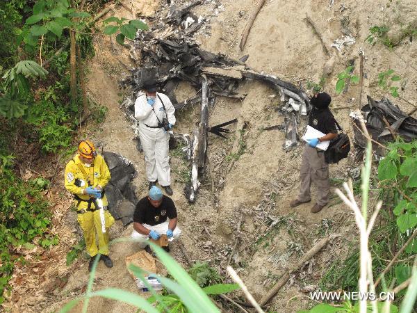 Rescuers work at the site of the plane crash in Changallo region close to San Salvador, capital of El Salvador, May 15, 2011. The pilot and two Chinese nationals were killed on Sunday in El Salvador when the plane crashed, the fire department said. 