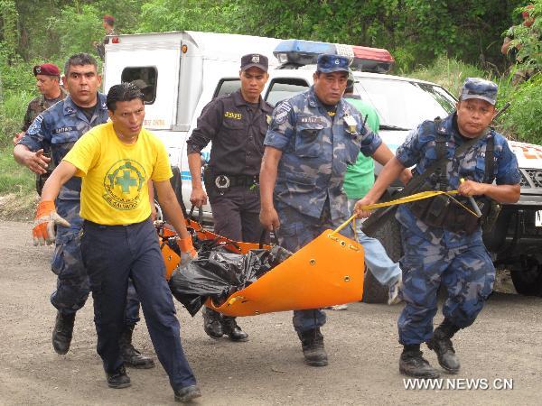 Rescuers carry the body of a victim in a plane crash in Changallo region close to San Salvador, capital of El Salvador, May 15, 2011.