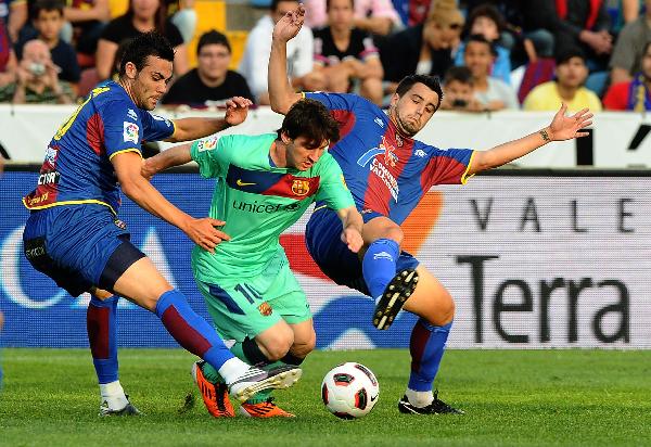 Barcelona's Lionel Messi (C) is challenged by Levante's Vicente Iborra (L) and Xisco Nadal during their Spanish first division soccer match at Ciutat de Valencia stadium in Valencia May 11, 2011. (Xinhua/AFP Photo)