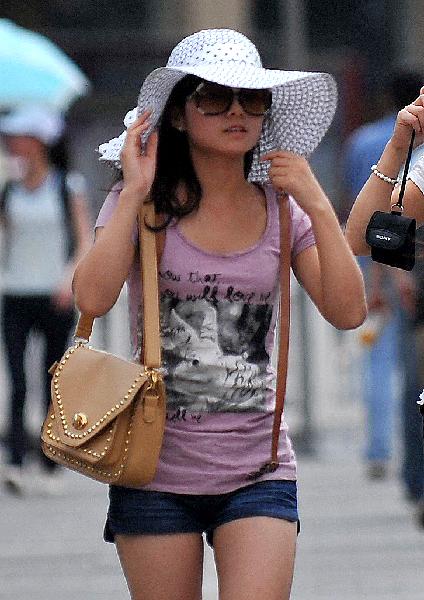 A pedestrian wears a hat to block the sunshine in Xi&apos;an, capital of northwest China&apos;s Shaanxi Province, May 17, 2011. The highest temperature in Xi&apos;an rose to 35 degrees Celsius on Tuesday. Temperatures in parts of the province are expected to exceed 35 degrees Celsius in the next three days, according to the local observatory. 