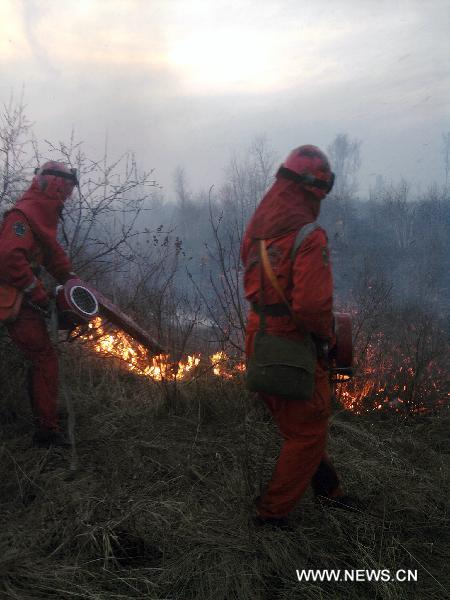 Fire-fighting personnel try to put out a wildfire in a forest under the administration of the Bailang forest bureau in the Dahinggan Mountains in the northeast area of north China&apos;s Inner Mongolia Autonomous Region, May 17, 2011. 