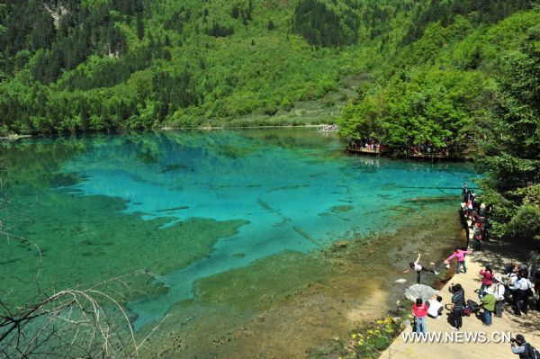 Tourists visit the peacock lake in the Jiuzhaigou scenery spot in southwest China's Sichuan Province, on May 18, 2011. After three years' remedy and recovery, Jiuzhaigou, a renowned resort once had been badly affected by a deadly earthquake, is booming in its tourism business, with the daily reception number reaching nearly 10,000 in May. [Xinhua/Chen Haining] 