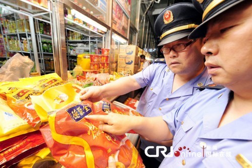 Workers from Beijing municipal trade and industry bureau check the Quanjude roast ducks in a shop near the Beijing Railway Station.