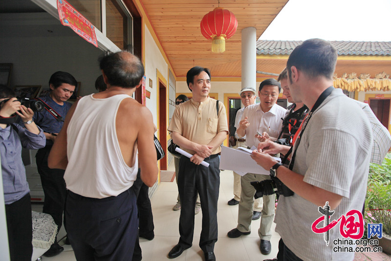 A 24-member reporting team headed by China International Publishing Group (CIPG) Vice President Lu Cairong (Central )pays a visit to Xinxing Town, Pengzhou City, severely hit by a devastating earthquake in 2008, to report the general condition of the house rebuilding program there.[Photo: Yang Jia/China.org.cn]