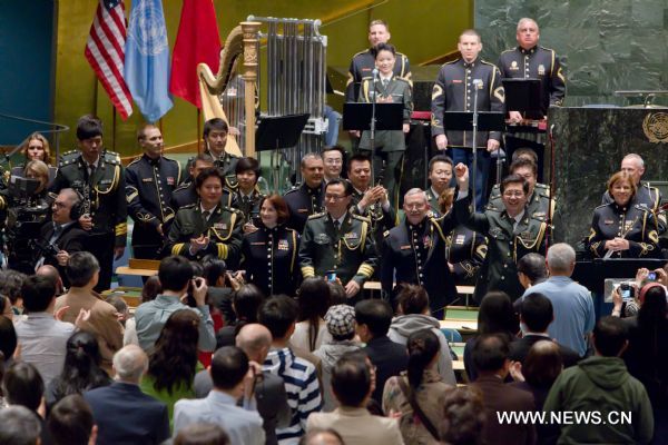 China's conductors Yu Hai (1st R) and Zhang Zhirong (3rd R), U.S. conductor Thomas Rotondi JR. (2nd R), China's tenor Dai Yuqiang (5th R) and U.S. soprano Leigh Ann Hinton greet the audience after a joint concert by the Military Band of the People's Liberation Army of China and the Untied States Army Band 'Pershing's Own' at the United Nations headquarters in New York, the United States, May 20, 2011. 