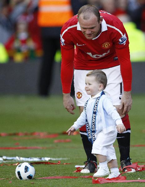 Manchester United's Wayne Rooney is pictured with his son Kai after celebrating with the English Premier League trophy after their match against Blackpool at Old Trafford, Manchester, England, Sunday, May 22, 2011. Manchester United celebrated winning the league for a 19th time beating Liverpool's long standing record. (Xinhua/Reuters Photo)