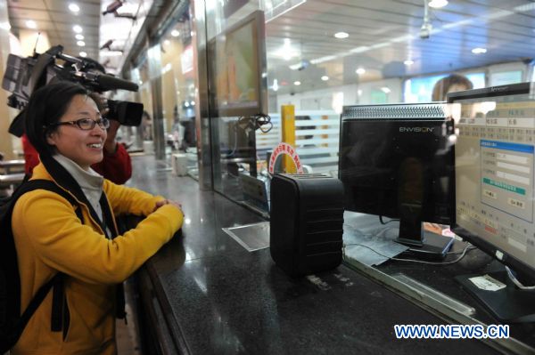 Yang Aining is seen standing at the ticket counter to buy a real-name ticket of high-speed train at the railway station in Harbin, capital of northeast China's Heilongjiang Province, May 23, 2011. The real-name ticket system of high-speed trains will be implemented on June 1, 2011. (Xinhua/Wang Song) (cxy) 