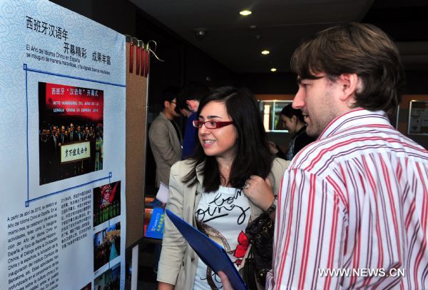 Spanish people view the posters about 'Year of Chinese Language in Spain' outside examination rooms for the Chinese Proficiency Test (HSK) in Madrid, May 21, 2011. Over 900 people attended Saturday's HSK exam in Madrid. More than 2,000 Spanish people took part in various kinds of Chinese language tests in the first half of the year, making spain having the most people taking Chinese language tests among european countries. 
