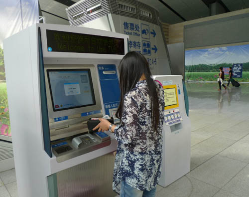 A girl buys a train ticket from a ticket vending machine installed with an ID card reader in the southern railway station of Beijing on Sunday, May 22, 2011. 