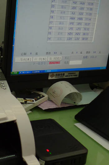 An ID card reader seen besides a computer at an authorized ticket office coded 'West A018' located in eastern Beijing on Sunday, May 22, 2011. 