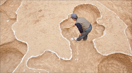 An archaeologist cleans the surface of an excavation site at Hujiaying village in Yanqing county on Friday. 