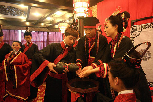 The bridegroom and bride wash their hands before proposing a wedding-toast during the ceremony in Gansu, capital of Northwest China's Lanzhou province on Sunday, May 22, 2011. The cleaning of hands is a ritual which means from then on the couple will live jointly, hand-in-hand for the good and bad of their marriage. 