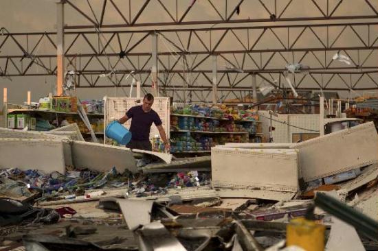 A man stands amid the remains of a Wal-Mart store, after it was hit by a tornado, in Joplin, Missouri May 22, 2011.