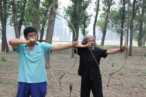 Yang Fuxi (right), practices archery with his son in his spare time.