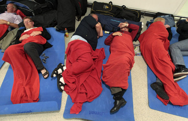 Passengers sleep on the floor in the main terminal at Edinburgh Airport, in Scotland May 24, 2011. [Agencies]