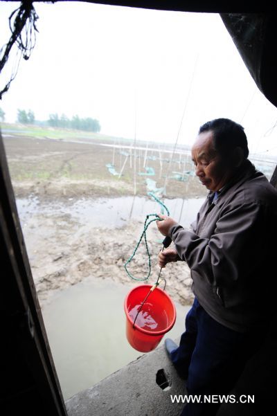 Fisherman Shu Zhenjia fetches water from the partially dried-up Honghu Lake in Honghu City, central China's Hubei Province, May 24, 2011. Plagued by a severe drought which is spreading throughout China's southern regions, Honghu Lake has dwindled by a third in water surface and dropped down to less than 40 centimeters in its deepest place. (Xinhua/Hao Tongqian) (zn) 