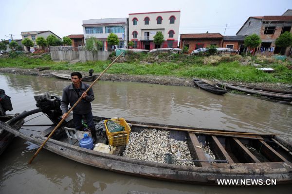 Fisherman Shi Caizhong sells dead fish along a stream near the Honghu Lake in Honghu City, central China's Hubei Province, May 24, 2011. All fishes Mr. Shi fed in his fishery in Honghu Lake were dead because of drought in recent days. Plagued by a severe drought which is spreading throughout China's southern regions, Honghu Lake has dwindled by a third in water surface and dropped down to less than 40 centimeters in its deepest place. (Xinhua/Hao Tongqian) (zn) 